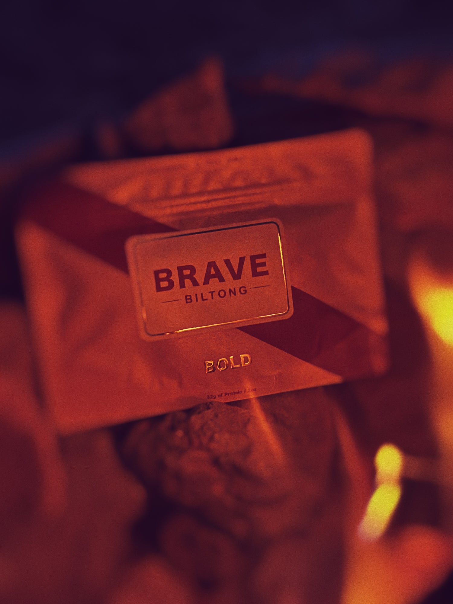 Brave Biltong packaging next to a campfire
