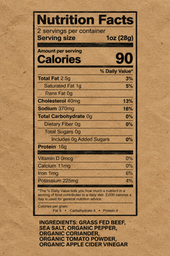 A Nutrition Facts label printed on a brown kraft paper background, showing serving size 1 oz (28g) and a list of ingredients including grass fed beef, organic pepper, organic coriander, organic tomato powder, and organic apple cider vinegar.